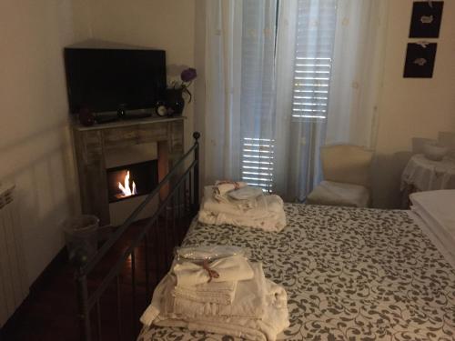 a bedroom with a fireplace and towels on a bed at Casa tipica siciliana patronale home BedandBreakfast TreMetriSoprailCielo Camere con vista, colazione interna in terrazzo panoramico in Caltagirone
