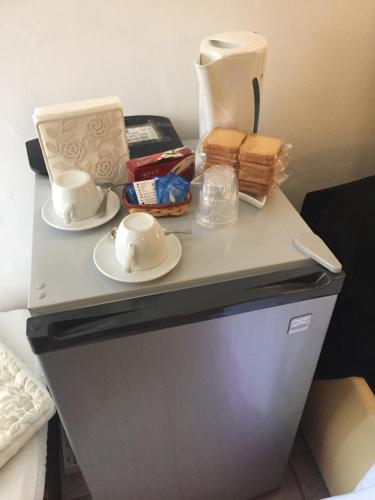 a table with two cups and plates on top of a refrigerator at Casa tipica siciliana patronale home BedandBreakfast TreMetriSoprailCielo Camere con vista, colazione interna in terrazzo panoramico in Caltagirone