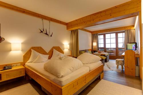 a bedroom with a bed and a living room at Am Dorfplatz Suites - Adults friendly in Sankt Anton am Arlberg