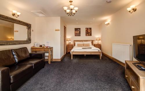 ein Wohnzimmer mit einem Bett und einem Sofa in der Unterkunft Acorns Old Farm in Bristol