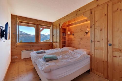 1 dormitorio con 1 cama en una habitación de madera con ventana en Altiplano 003 en Verbier