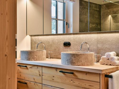 two sinks in a bathroom with two mirrors at Omesberg-Hütt'n in Lech am Arlberg