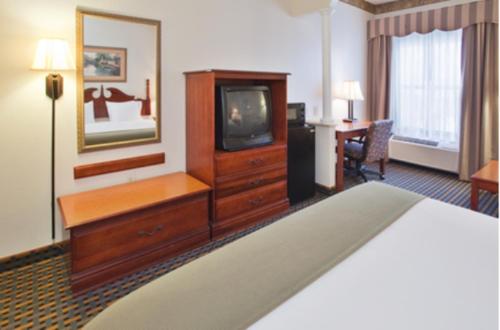 a hotel room with a bed and a television at Holiday Inn Express Hotel & Suites Laurinburg by IHG in Laurinburg
