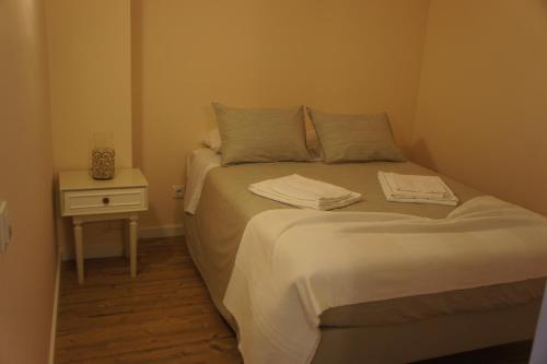 a small bedroom with a bed and a night stand at Apartamento Copacabana in Estoril