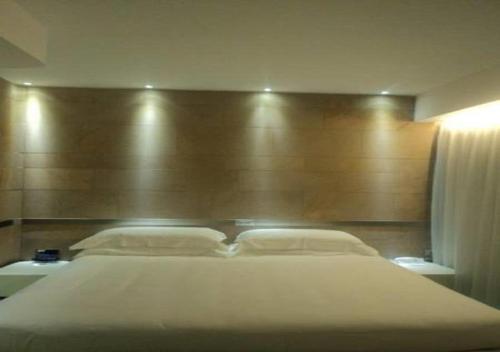 a bedroom with a large bed with a wooden headboard at A Point Arezzo Park Hotel in Arezzo
