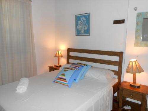 a bedroom with a bed with blue pillows on it at Pousada Baluarte in Salvador