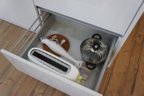 a drawer with a hair dryer and other items in it at Apartamento Copacabana in Estoril