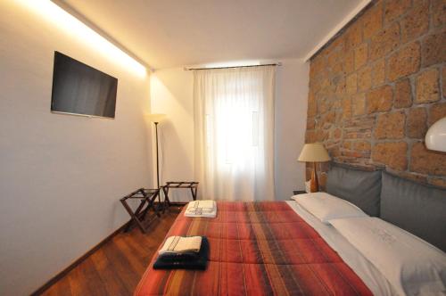 a bedroom with a bed with a brick wall at Appartamento Mia in Orvieto