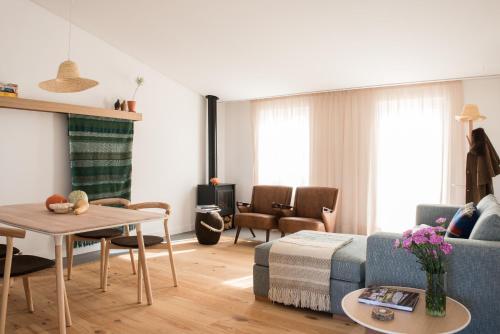 a living room with a blue couch and a table at Craveiral Farmhouse by Belong Staying & Feeling in São Teotónio