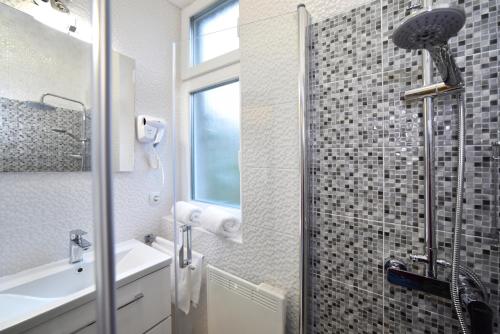 uma casa de banho com um chuveiro, um lavatório e um espelho. em Apartment Sermazi em Zagreb