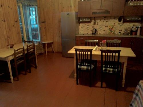 a kitchen with a table and chairs and a refrigerator at Guest House Gabo in Mestia