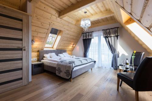 Giewont Residence في كوشتيليسكا: غرفة نوم بسرير في غرفة بسقوف خشبية