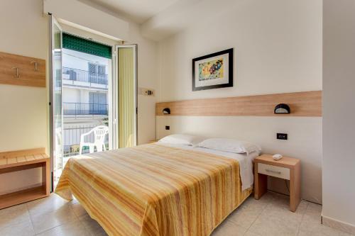 a bedroom with a bed and a large window at Hotel Villa Boschetti in San Mauro a Mare