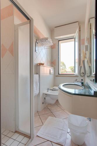 a bathroom with a tub and a toilet and a sink at Hotel Villa Boschetti in San Mauro a Mare