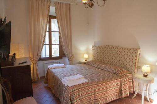 1 dormitorio con 1 cama, TV y ventana en Villa Torricelli Scarperia - Il Giardinetto Residence en Scarperia