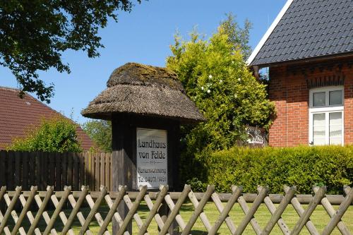a building with a sign in front of a fence at Landhaus von Felde in Esens
