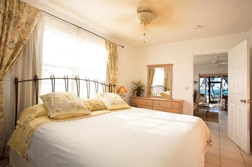 1 dormitorio con 1 cama blanca grande y ventana en Hollywood Beach Suites Turks and Caicos, en NCA