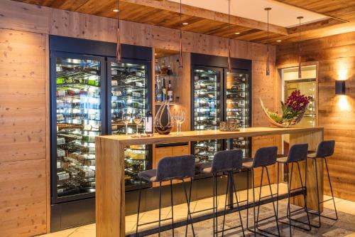 a bar in a wine tasting room with bar stools at Hotel Hubertus in Sölden
