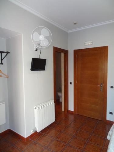 a room with a toilet and a television on the wall at Pensión La Bilbaina - Albergue Logroño in Logroño