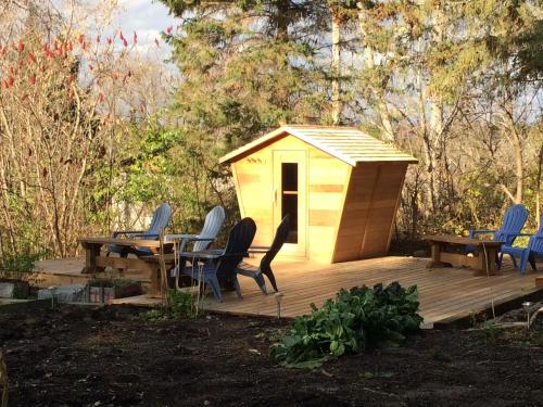 a wooden deck with chairs and a shed at La Grange Country Inn in Wakefield
