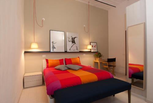 - une chambre avec un lit et une couverture colorée dans l'établissement The yellow house, à Rome