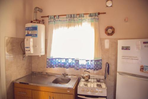 una pequeña cocina con fregadero y ventana en El Balcón de Punilla en Villa Giardino