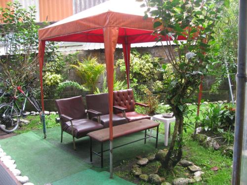 a gazebo with two chairs and a red umbrella at Transilvania in Baños