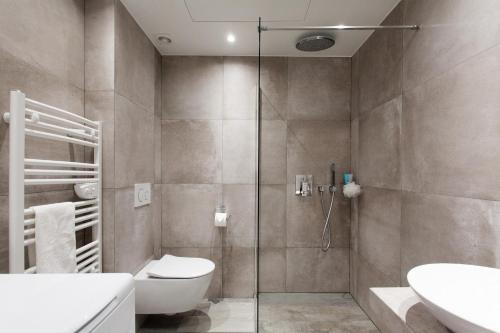 a bathroom with a shower and a toilet and a sink at Palladium Palais des Festivals in Cannes