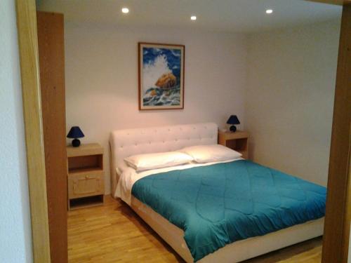 a bedroom with a large bed with a blue blanket at Apartment Mira in Cres