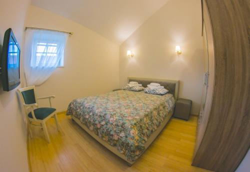 a small bedroom with a bed and a chair at Vila Gija in Nida