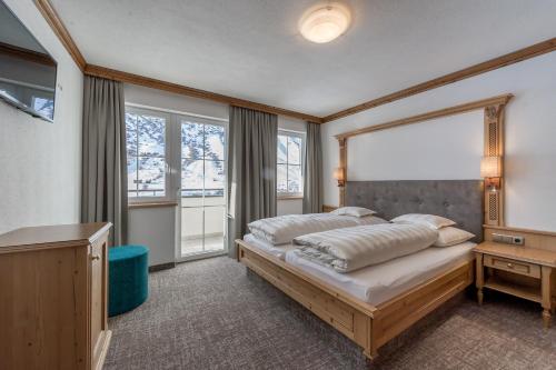 a bedroom with a bed with a large window at Landhaus Jenewein in Obergurgl