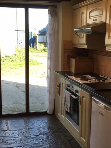 a kitchen with a stove top oven next to a door at The Horse Barn in Corsham