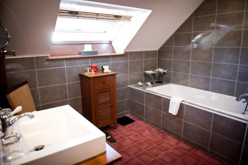 La salle de bains est pourvue d'un lavabo et d'une baignoire. dans l'établissement Domaine De Barive, à Sainte-Preuve