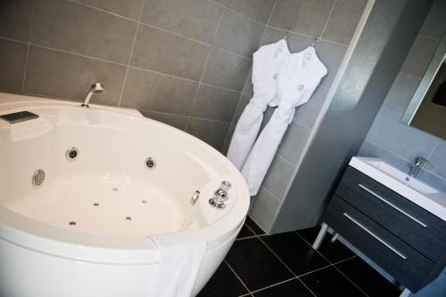 a bathroom with a white tub and a sink at Domaine De Barive in Sainte-Preuve