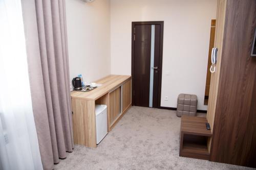 a small room with a desk and a door at Lumarc Hotel in Bishkek
