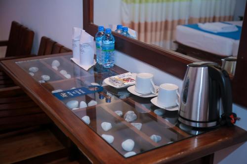 a glass table in a hotel room with a coffee maker at Cozy Sea view Inn in Hikkaduwa