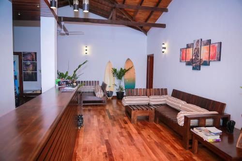 a living room with couches and a wooden floor at Cozy Sea view Inn in Hikkaduwa