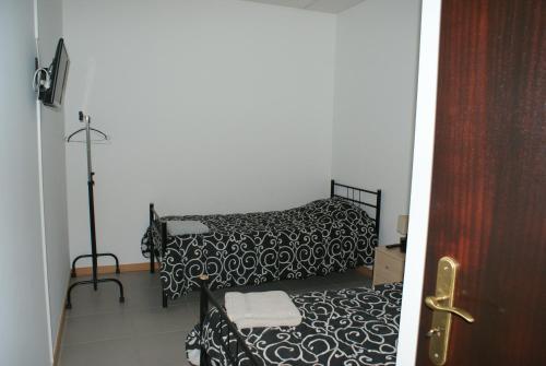 um quarto com 2 camas com lençóis brancos e pretos em Quartos do Lagar na Golegã