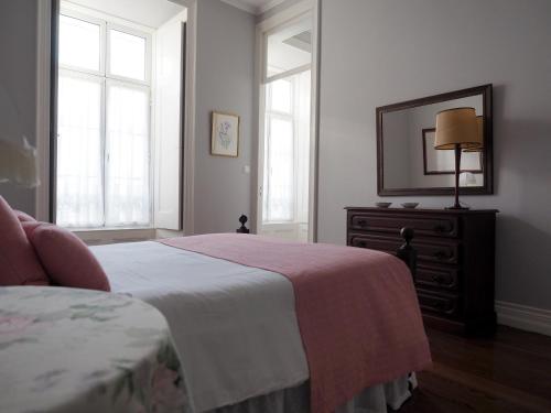 a bedroom with a bed and a dresser and a mirror at Porta26 in Ponta Delgada