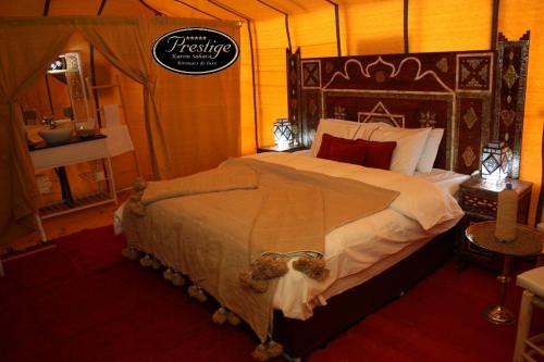 a bedroom with a large bed in a tent at Karim Sahara Prestige in Zagora