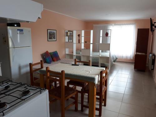 a kitchen and dining room with a table and chairs at Alem in Puerto Madryn