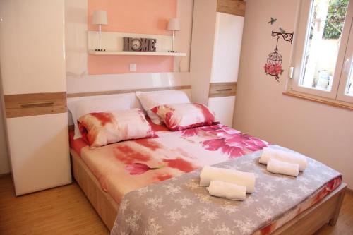 mała sypialnia z łóżkiem z kwiatami na nim w obiekcie Vacation house "Viola" w Fažanie