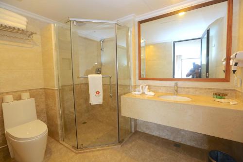 a bathroom with a shower and a toilet and a sink at Kaani Grand Seaview in Maafushi