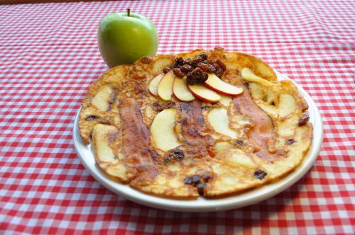 a plate of food with an apple on a table at The Sleeping Moose Cottage in Birch Plain