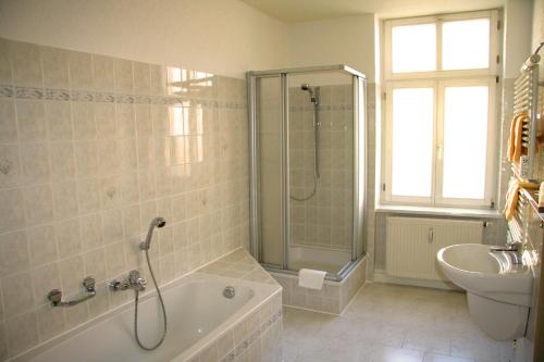 Hotel Wettin في Treuen: حمام مع دش وحوض استحمام ومغسلة