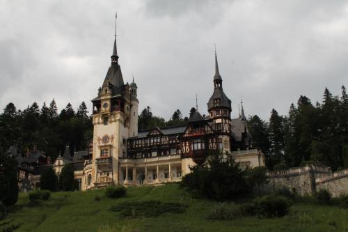 an old castle with a clock tower on a hill at Studio Lalelelor in Sinaia