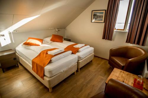 a hotel room with two beds and a chair at Gerdi Guesthouse in Gerdi