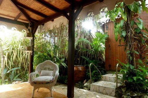 a patio with a chair and some plants at Les Hauts de Terrasson in Les Abymes