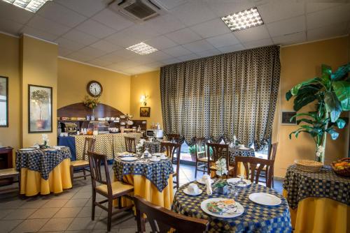 a restaurant with blue and yellow tables and chairs at Greta Rooms Hotel in Mazara del Vallo