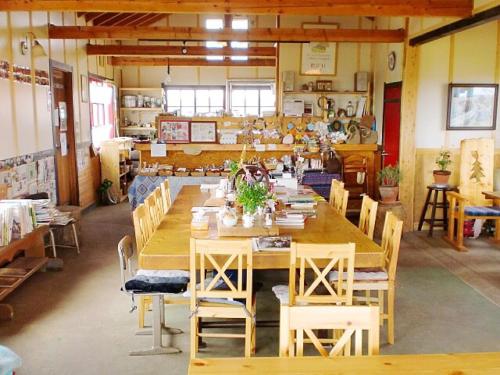 een grote eetkamer met een lange tafel en stoelen bij Heart'n Tree in Tsurui